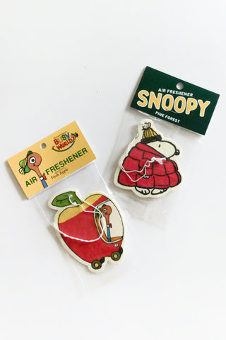 Two air fresheners on a white background, one with a Richard Scarrey apple car and the other with 'Snoopy' branding.