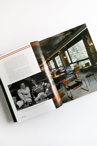 Open book showing a interior design layout with furniture and people.