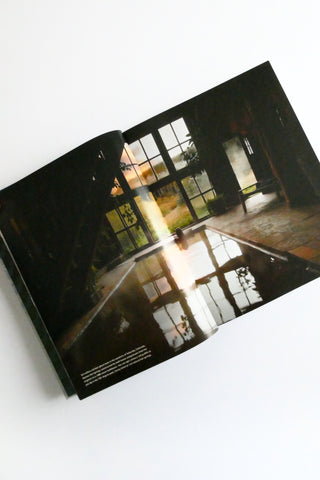 Open book showing a photograph of a room with large windows.