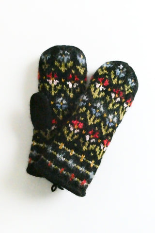 Pair of black mittens with colorful floral pattern on a white background