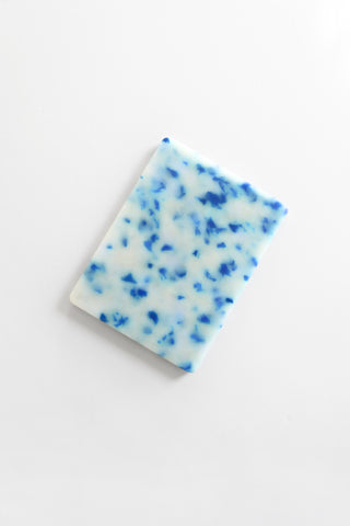 Cutting board with blue speckles on a white background