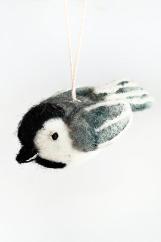 Felted bird ornament hanging on a white background