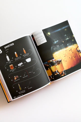 Open book showing a page with a diagram and another with a photograph of drinks on a white background