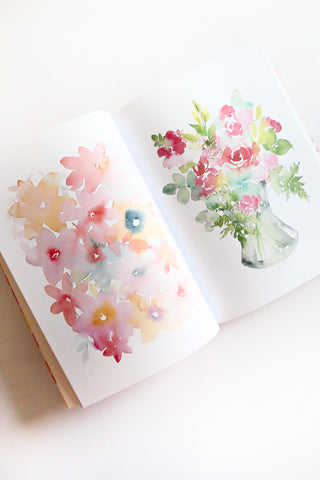 Book open to watercolor floral design on a white background