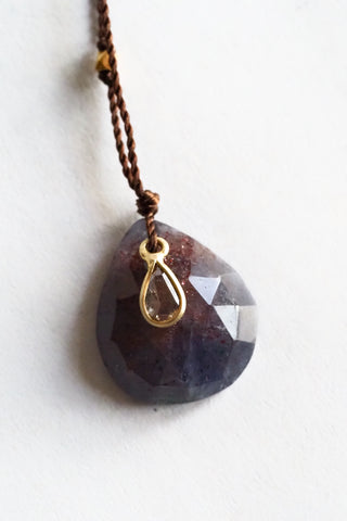 Necklace with a large faceted stone pendant and a smaller teardrop-shaped gold pendant on a white background.