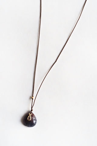 Necklace with a dark purple teardrop pendant on a white background