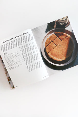 Open cookbook showing a cake recipe on a white surface