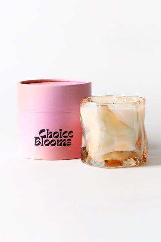 Glass candle with marbled design and pink container labeled 'Choice Blooms' on a white background