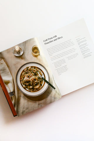 Pasta dish on a table with an open recipe book