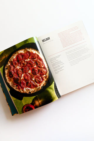 Open cookbook with a pizza on the page