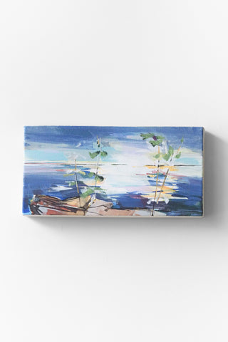 Abstract painting of a coastal scene displayed on a white wall.