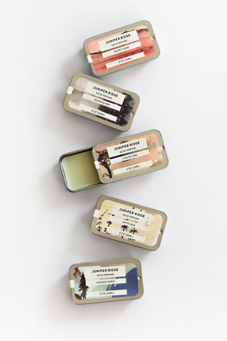 Collection of Juniper Ridge lip balm tins on a white background
