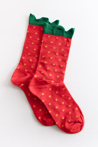 Red socks with green tops and yellow polka dots on a white background