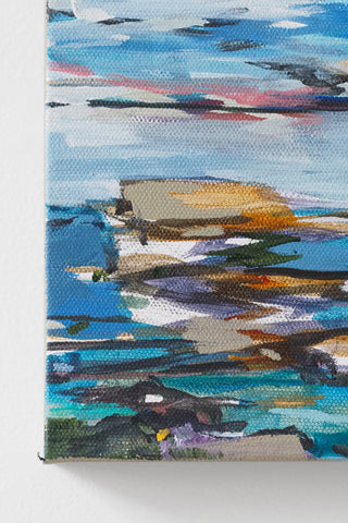 Close up shot of a coastal scene with colorful reflections on water