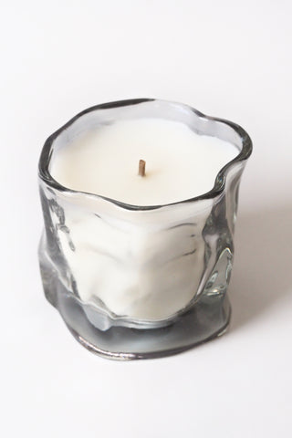 White candle in a glass holder on a white background