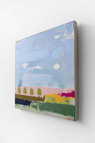 Abstract landscape painting with a blue sky, green fields, and colorful trees on a white wall.