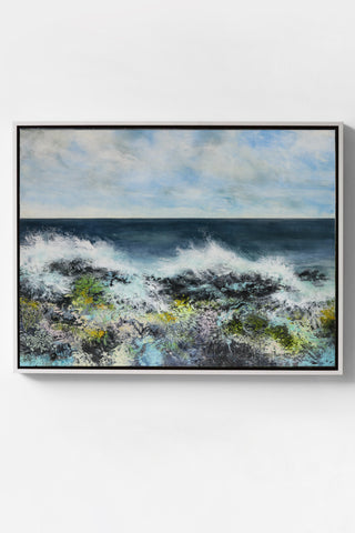 Framed abstract artwork with a blue sky and ocean scene on a white wall