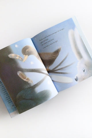 Open book with illustrations of birds on a white surface