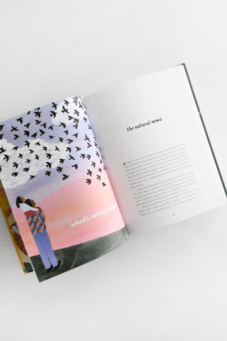 Open book with a cover featuring two people and a gradient background on a white surface.