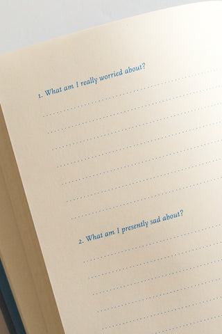 Notebook page with text prompts for self-reflection on worries and sadness.