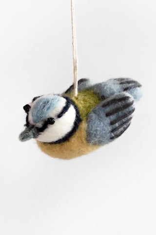 Felted bird ornament hanging on a white background