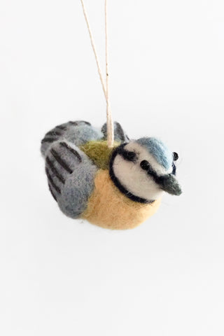 Felted bird ornament hanging on a white background