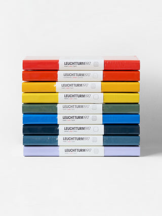 Stack of Leuchtturm1917 notebooks in various colors on a white background